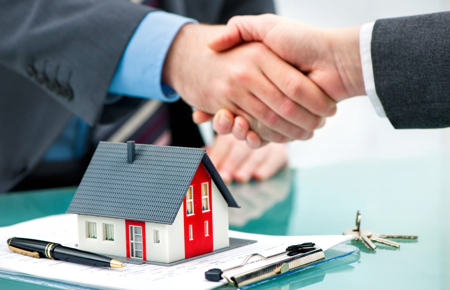Estate agent shaking hands with customer after contract signature